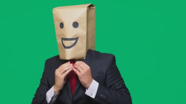 Concept van emoties, gebaren. een man met papieren zakken op zijn hoofd, met een geschilderde emoticon, glimlach, vreugde — Stockvideo