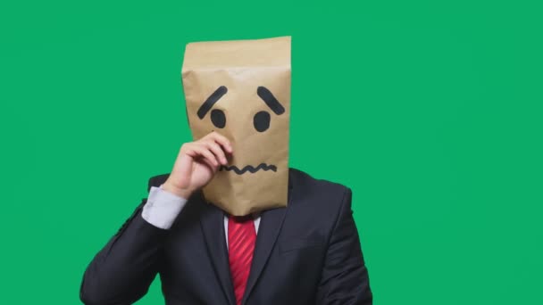 Концепция эмоций, жестов. мужчина с пакетом на голове, с нарисованной надписью плачет, грустит — стоковое видео