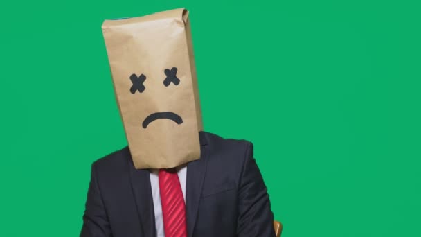Concept of emotion, gestures. a man with a package on his head, with a painted smiley, exhausted, tired — Stock Video