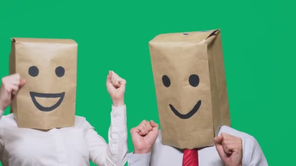 Concepto de emociones, gestos. un par de personas con bolsas en la cabeza, con un emoticono pintado, sonrisa, alegría, risa . — Vídeo de stock