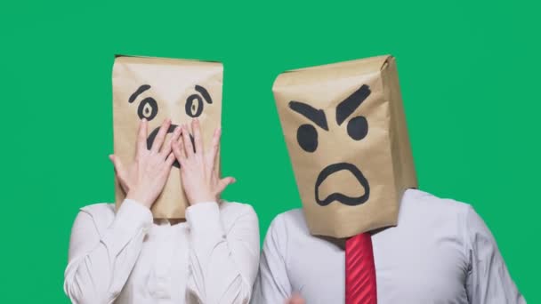 The concept of emotions and gestures. Two people in paper bags with smiles. Aggressive smiley swears. Second scared — Stock Video