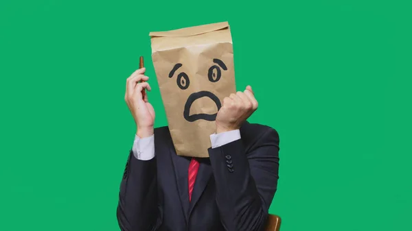 Koncepcja emocje, gesty. człowiek z torby papierowe na głowie, z malowane emotikon, strach. rozmowy na telefon komórkowy — Zdjęcie stockowe