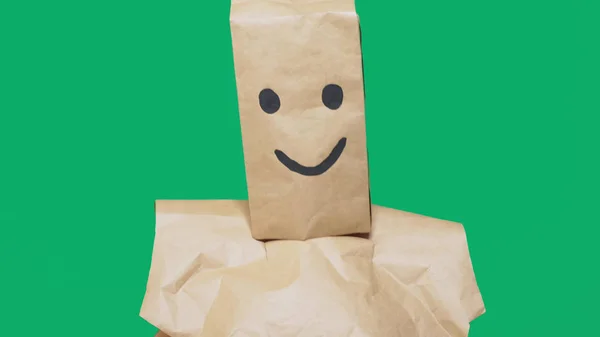 Konsep emosi, gerak tubuh. seorang pria dengan kantong kertas di kepalanya, dengan emoticon dicat, tersenyum, sukacita — Stok Foto