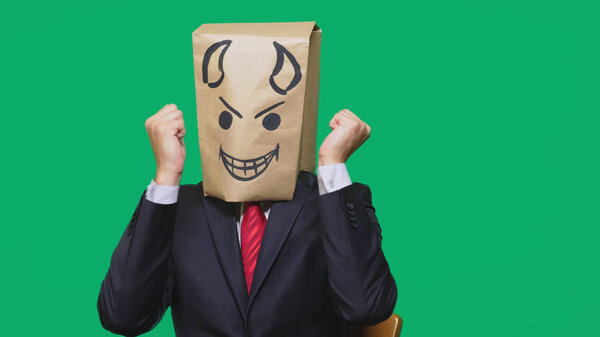 concept of emotion, gestures. a man with a package on his head, with a painted smiley angry, sly, gloating, devil