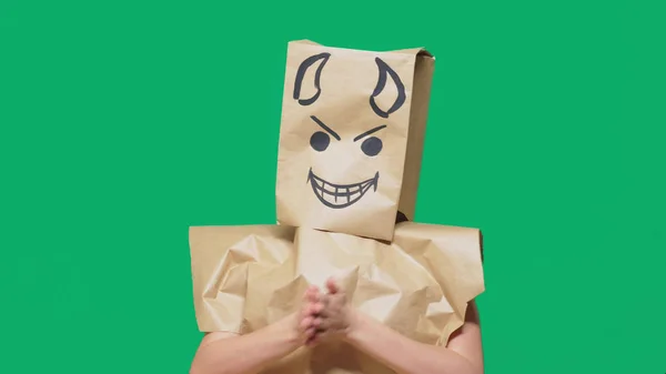 Concepto de emoción, gestos. un hombre con un paquete en la cabeza, con una sonrisa pintada enojado, astuto, regodeo, diablo —  Fotos de Stock