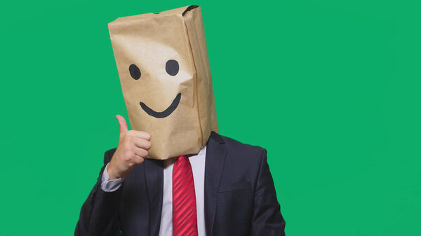 concept of emotions, gestures. a man with paper bags on his head, with a painted emoticon, smile, joy