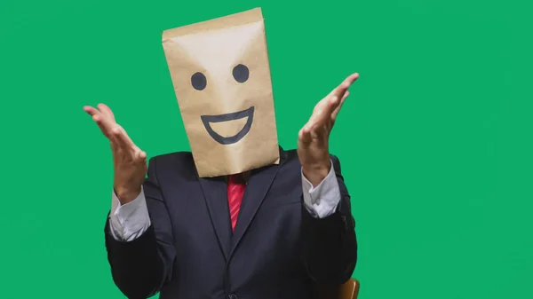 Concepto de emociones, gestos. un hombre con bolsas de papel en la cabeza, con un emoticono pintado, sonrisa, alegría —  Fotos de Stock