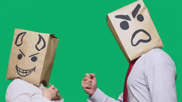 Concept of emotions, gestures. a man with a package on his head, with a painted emoticon, one angry screaming, another crafty, and the devil laughs. trolling, lies, provocation — Stock Photo, Image