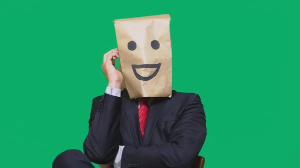 Koncepcja emocje, gesty. człowiek z torby papierowe na głowie, malowane emotikon, uśmiech, radość — Zdjęcie stockowe