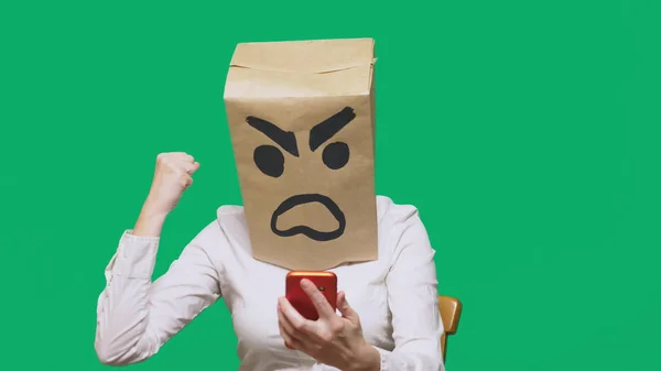 Conceptul de emoție, gesturi. un om cu un pachet pe cap, cu un zâmbet pictat agresiv, furios. Vorbind pe un telefon mobil — Fotografie, imagine de stoc