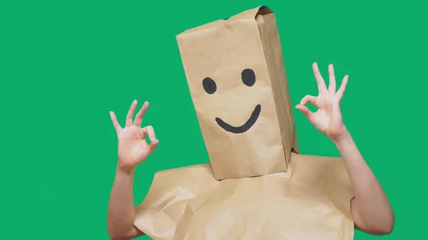 Concept of emotions, gestures. a man with paper bags on his head, with a painted emoticon, smile, joy — Stock Photo, Image