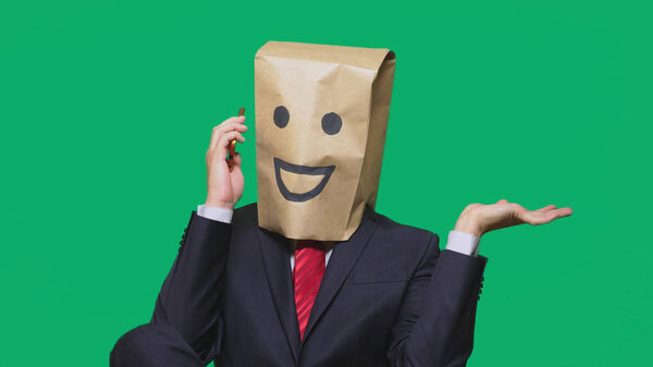 concept of emotions, gestures. a man with paper bags on his head, with a painted emoticon, smile, joy. talking on a cell phone