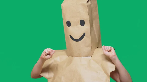 Concept of emotions, gestures. a man with paper bags on his head, with a painted emoticon, smile, joy — Stock Photo, Image