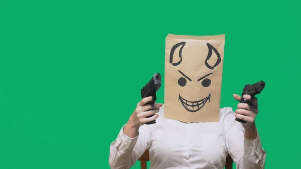 Pojmu emoce, gesta. muž s balíčkem na hlavě, malovaný obličej rozhněvaný, sly, škodolibě, ďábel, pistole v ruce — Stock fotografie