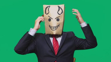 duygular, jest kavramı. haset, bir cep telefonu üzerinde konuşurken bir adam ile bir boyalı siyah gülen surat, şeytan, kurnaz, kafasına bir paketi ile.