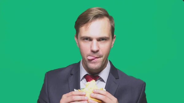 ビジネスマンの緑の背景にサンドイッチを食べるします。クイック ランチ コンセプト — ストック写真