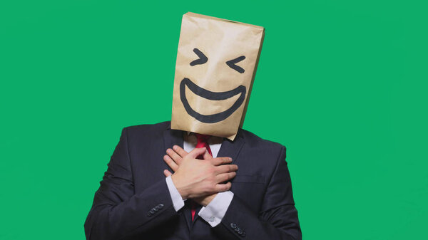 concept of emotions, gestures. a man with paper bags on his head, with a painted emoticon, smile, joy
