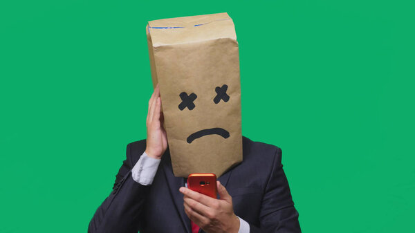concept of emotion, gestures. a man with a package on his head, with a painted smiley, exhausted, tired, talking on the phone