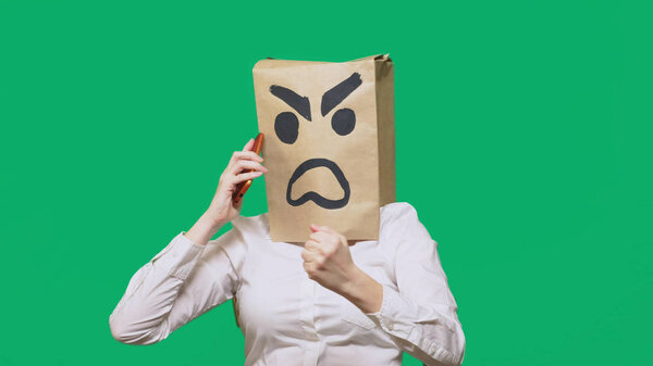 concept of emotion, gestures. a man with a package on his head, with a painted smiley aggressive, angry