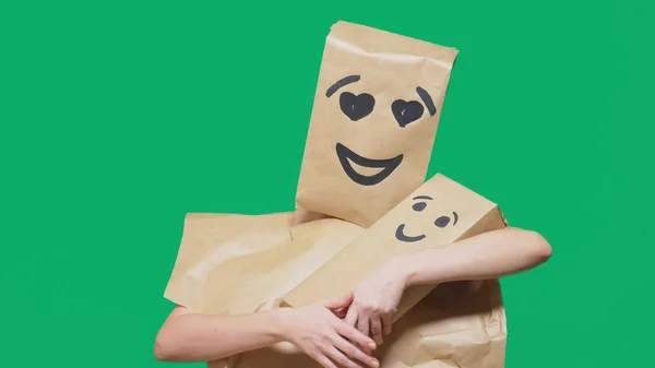 Concept of emotions, gestures. a man with a package on his head, with a painted emoticon, smile, enamored eyes. plays with the child painted on the box. — Stock Photo, Image