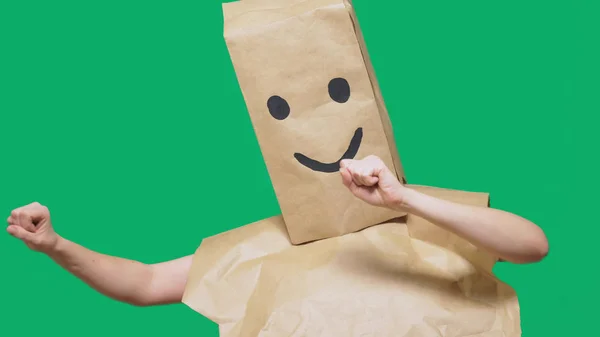 Concept of emotions, gestures. a man with paper bags on his head, with a painted emoticon, smile, joy — Stock Photo, Image