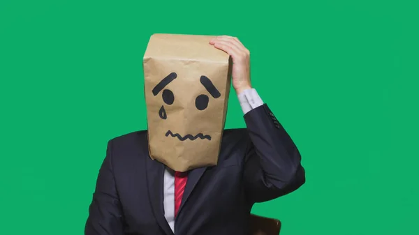 Conceptul de emoție, gesturi. un om cu un pachet pe cap, cu un zâmbet pictat, epuizat, obosit — Fotografie, imagine de stoc