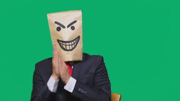 concept of emotion, gestures. a man with a package on his head, with a painted smiley angry, sly, gloating.