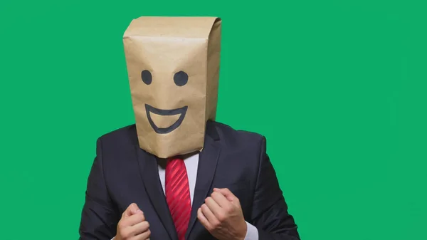 Concepto de emociones, gestos. un hombre con bolsas de papel en la cabeza, con un emoticono pintado, sonrisa, alegría — Foto de Stock