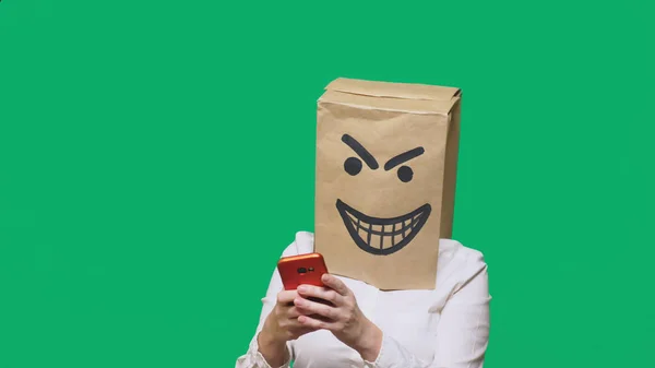 Concept van emotie, gebaren. een man met een pakket op zijn hoofd, met een geschilderde smiley boos, sluwe, leedvermaak — Stockfoto