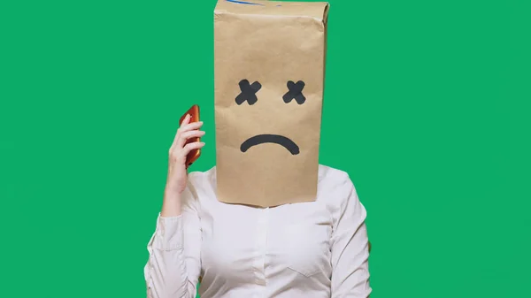 Conceptul de emoție, gesturi. un om cu un pachet pe cap, cu un zâmbet pictat, epuizat, obosit, vorbind la telefon — Fotografie, imagine de stoc