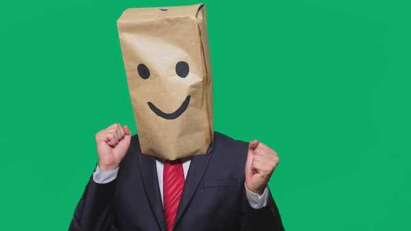 concept of emotions, gestures. a man with paper bags on his head, with a painted emoticon, smile, joy.