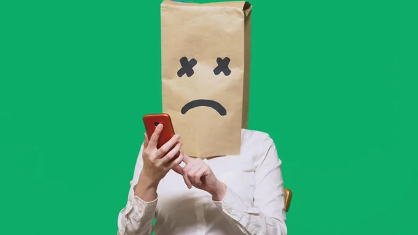 Концепция эмоций, жестов. мужчина с пакетом на голове, с разрисованным лицом, истощенный, уставший, разговаривающий по телефону — стоковое фото