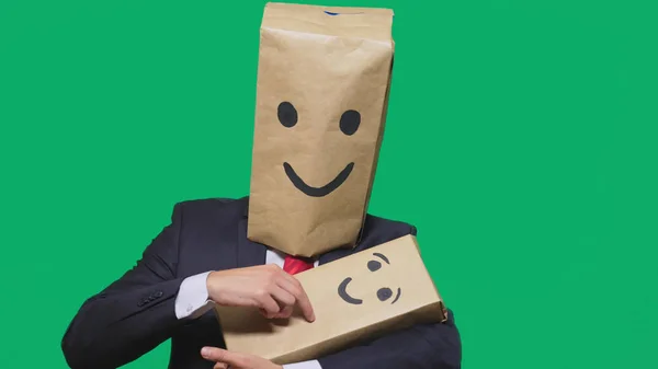 Concept of emotions, gestures. man with a package on his head, with a painted emoticon, smile, joy, laughter. plays with the child painted on the box. — Stock Photo, Image