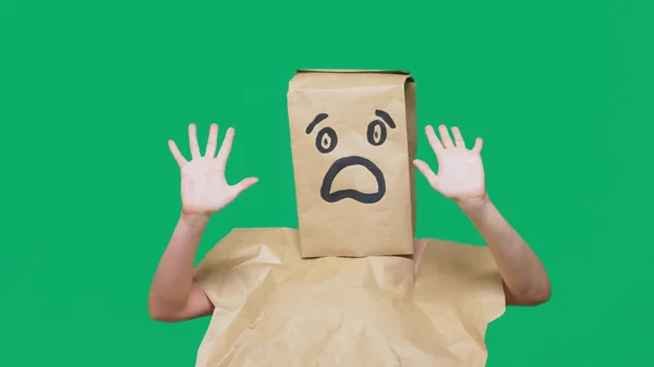 Concepto de emociones, gestos. un hombre con bolsas de papel en la cabeza, con un emoticono pintado, miedo . — Foto de Stock