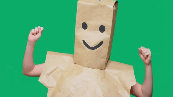 Concepto de emociones, gestos. un hombre con bolsas de papel en la cabeza, con un emoticono pintado, sonrisa, alegría —  Fotos de Stock