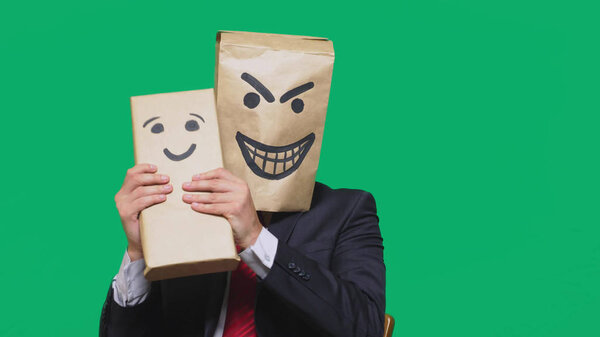 concept of emotions, gestures. a man with a package on his head, with a painted emoticon devil, crafty, gloating. plays with the child drawn on the box. childs deception, naivety