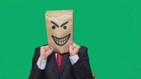 concept of emotion, gestures. a man with a package on his head, with a painted smiley angry, sly, gloating