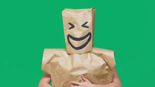 Concept of emotions, gestures. a man with paper bags on his head, with a painted emoticon, smile, joy — Stock Photo, Image