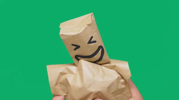 Konsep emosi, gerak tubuh. seorang pria dengan kantong kertas di kepalanya, dengan emoticon dicat, tersenyum, sukacita — Stok Foto