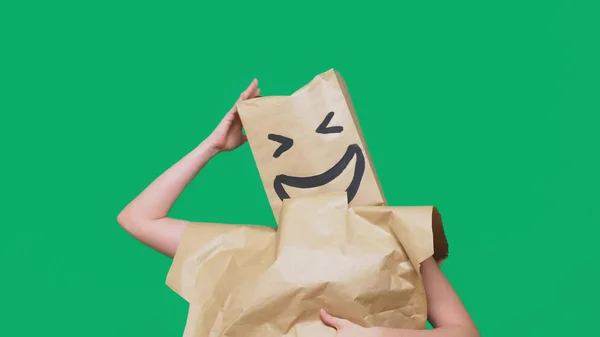Koncepcja emocje, gesty. człowiek z torby papierowe na głowie, malowane emotikon, uśmiech, radość — Zdjęcie stockowe