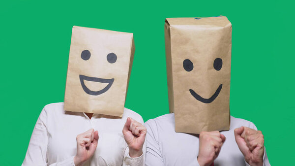 concept of emotions, gestures. a couple of people with bags on their heads, with a painted emoticon, smile, joy, laugh.