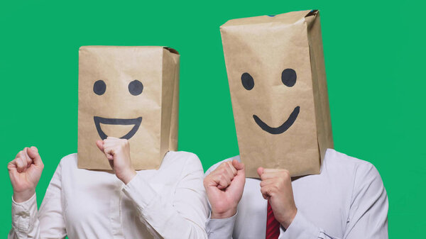 concept of emotions, gestures. a couple of people with bags on their heads, with a painted emoticon, smile, joy, laugh.