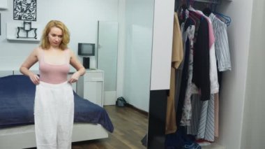 Giyim, dolap, moda, stil ve insanlar kavramı. şaşkın sarışın giysi dolabı duran ve kendisi aynaya bakıyorum, bir seçim yapar.