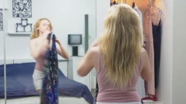 Giyim, dolap, moda, stil ve insanlar kavramı. şaşkın sarışın giysi dolabı duran ve kendisi aynaya bakıyorum, bir seçim yapar