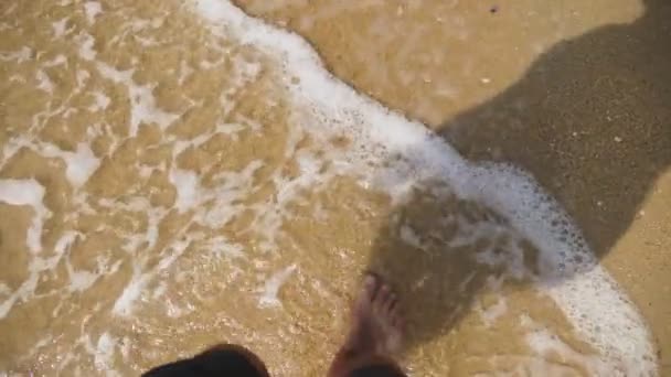 Mens benen op het zand van de zee en de Golf, ontspanning op de oceaan strand, zomervakantie. — Stockvideo