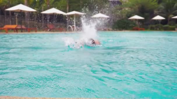 Gioioso giovane bell'uomo che salta in piscina, in vacanza in hotel. concetto di vacanza estiva — Video Stock
