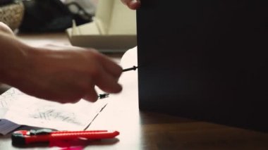 Genç bir adam bağımsız olarak mobilya evinin oturma odasında toplar. Bir adam bilgisayar masası toplar.