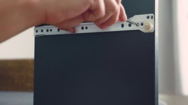 Genç bir adam bağımsız olarak mobilya evinin oturma odasında toplar. Bir adam bilgisayar masası toplar.