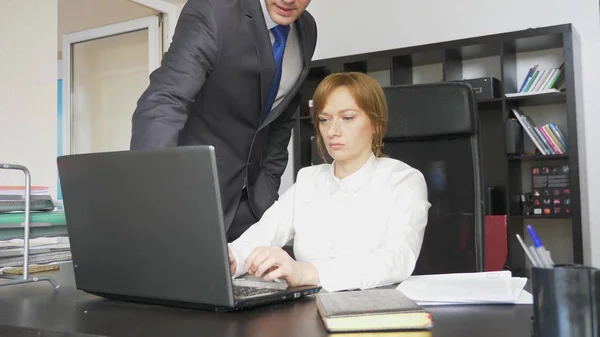 Homem e mulher em ternos rigorosos no trabalho em laptop, documentos, discussão no escritório . — Fotografia de Stock