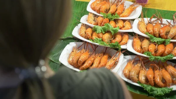 一个女人看夜市上的产品。泰国街头食品。夜市在泰国 — 图库照片